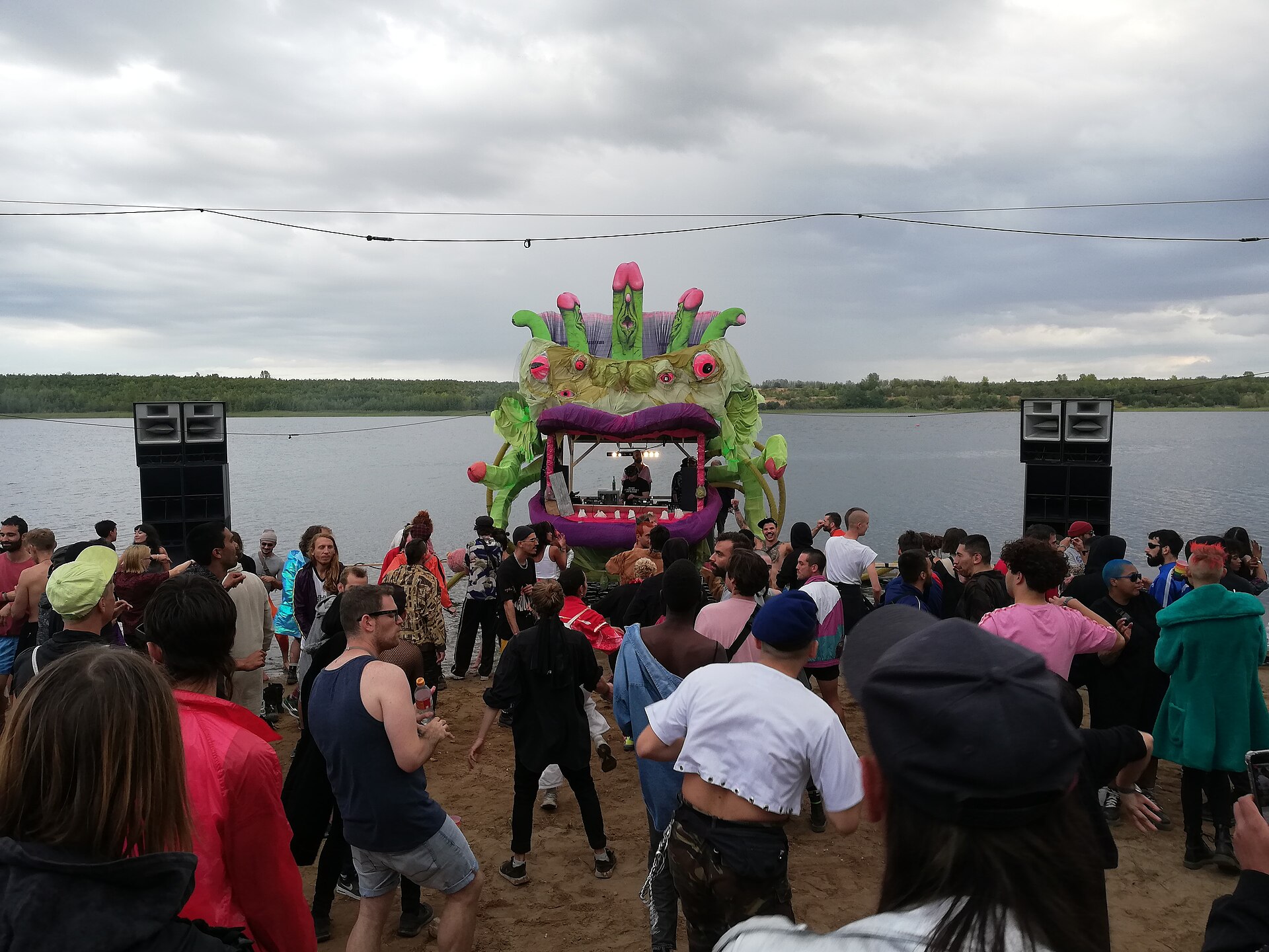 Crowd dancing with hands raised, evoking clubbing in the 90s