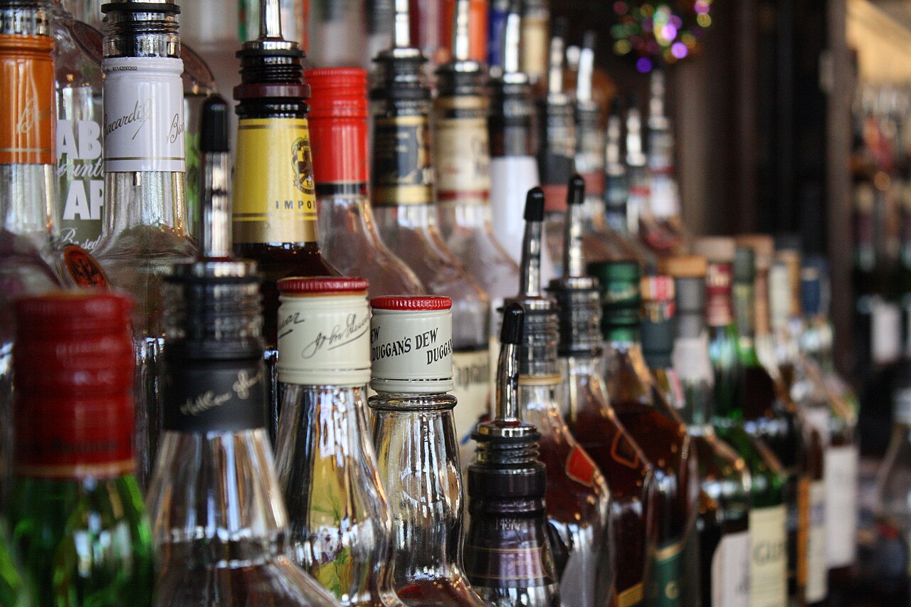 Rows of liquor bottles behind a bar as big alcohol loses market value
