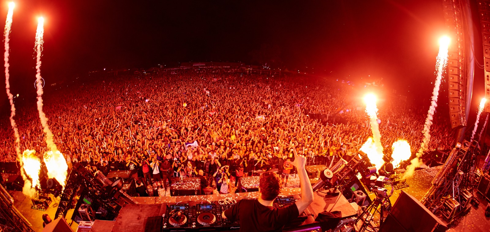 A festival DJ at the decks, illustrating a feature on DJ stage names