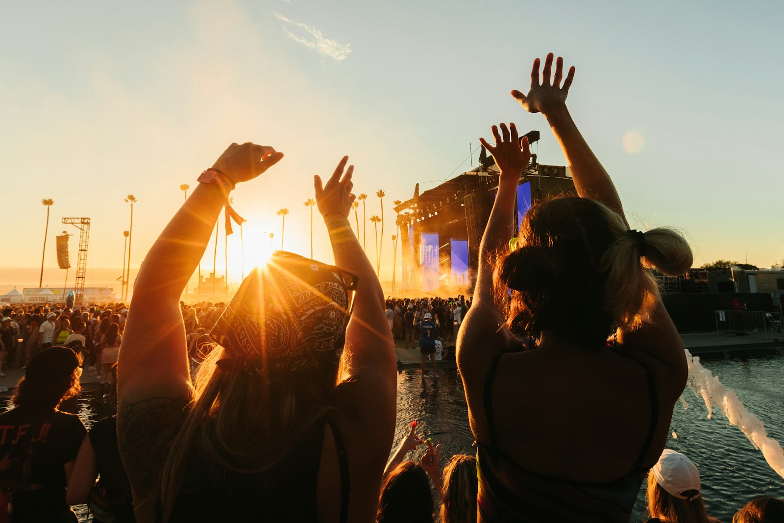 Crowd dancing with hands raised at an electronic music festival, illustrating the link between electronic music and anxiety relief