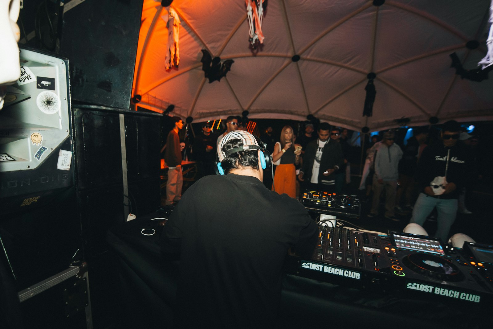 DJ playing to a crowd behind the decks, evoking the Fatboy Slim facts about Norman Cook