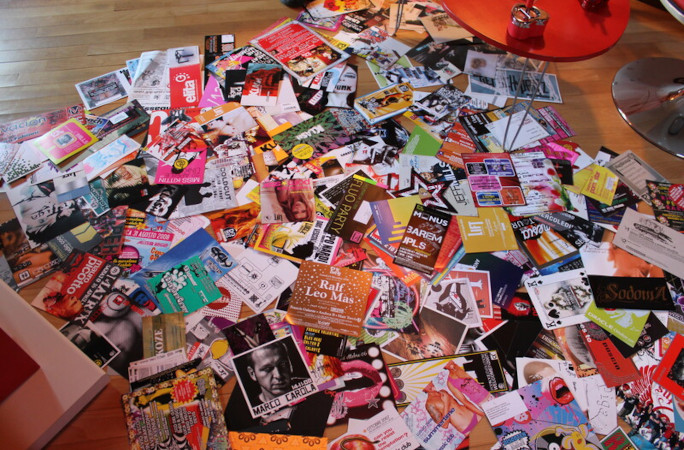 Part of the rave flyer collection spread across a floor
