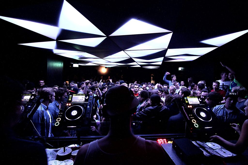View from the DJ booth over a packed club dancefloor