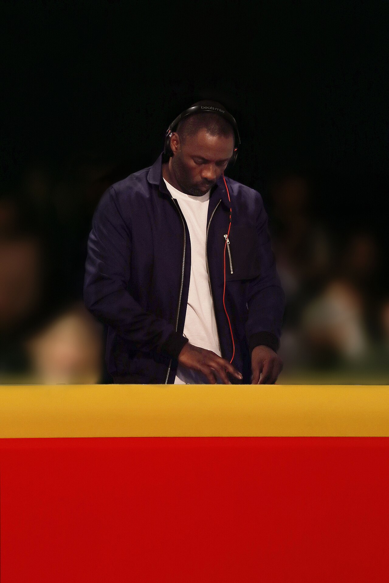 Idris Elba DJ set in 2013, headphones on behind the booth