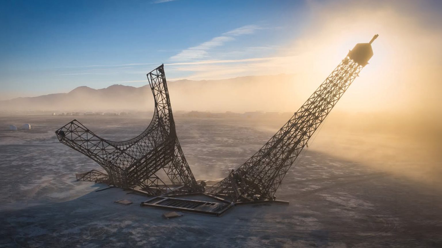 Broken Eiffel Tower at Burning Man 2026, the Eiffela Broken Dream installation on the playa at sunrise