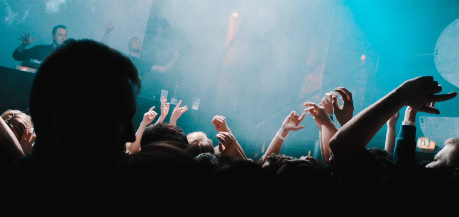 Nightclub crowd with hands in the air, illustrating research on women over 40 raving